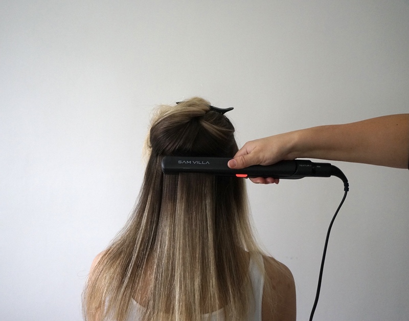 A person using a flat iron