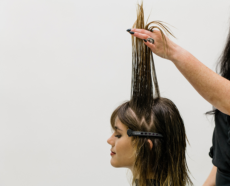 A person getting her hair doneDescription automatically generated with low confidence