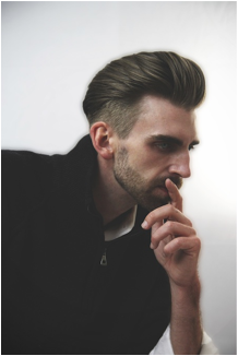 photo of a man with his hand on his chin with a rockabilly haircut 