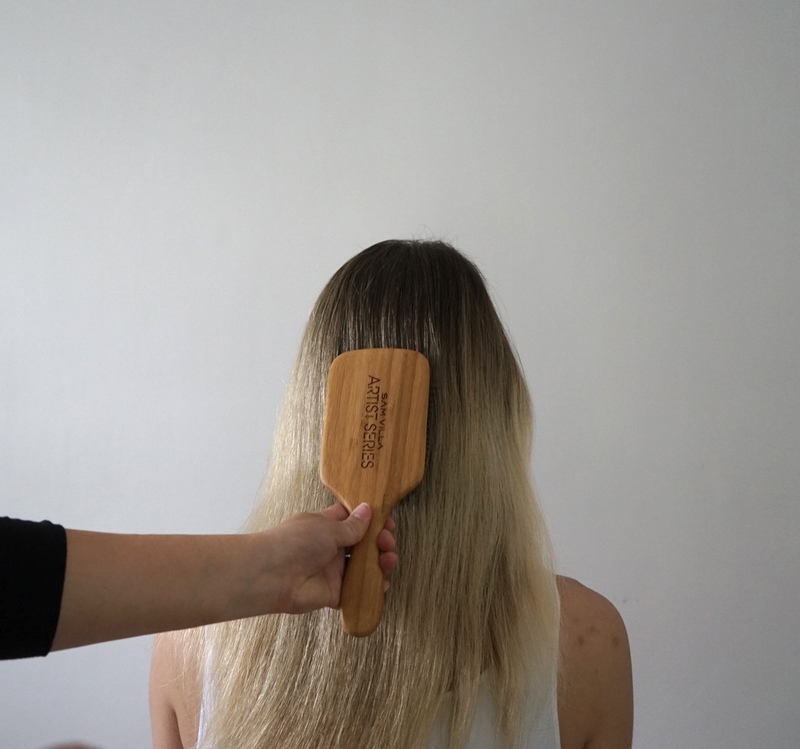 A picture containing person brushing hair, wall, indoor